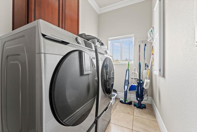 washroom featuring cabinet space, light tile patterned flooring, crown molding, separate washer and dryer, and baseboards