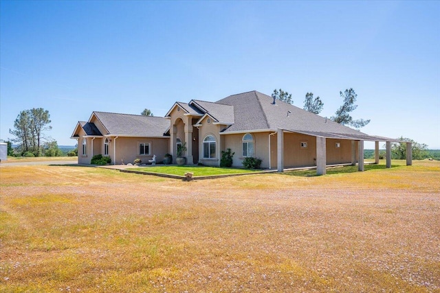 view of front of house featuring stucco siding and a front yard