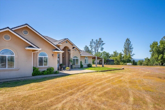 view of front of property with stucco siding and a front lawn