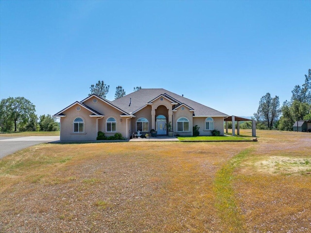view of front facade with a front yard and stucco siding