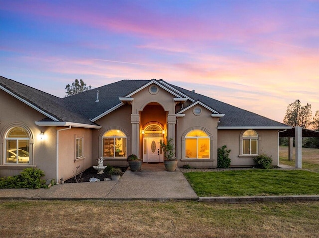 ranch-style home with stucco siding and a front yard