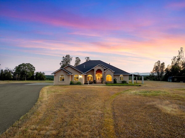 ranch-style home featuring a lawn