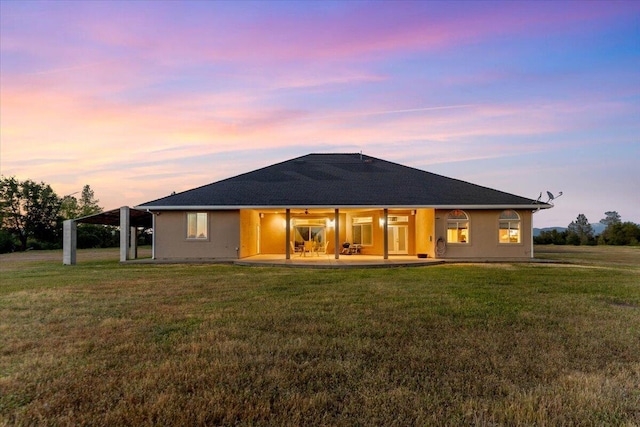 back of house with a lawn and a patio