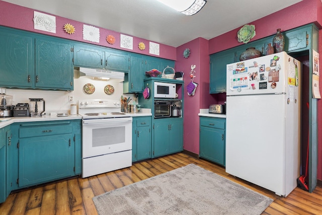 kitchen with white appliances, light countertops, under cabinet range hood, and wood finished floors