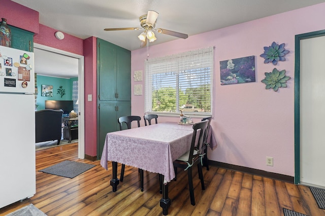 dining space with ceiling fan, baseboards, and hardwood / wood-style floors