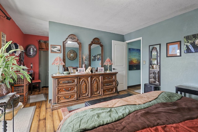 bedroom with a textured ceiling and hardwood / wood-style flooring