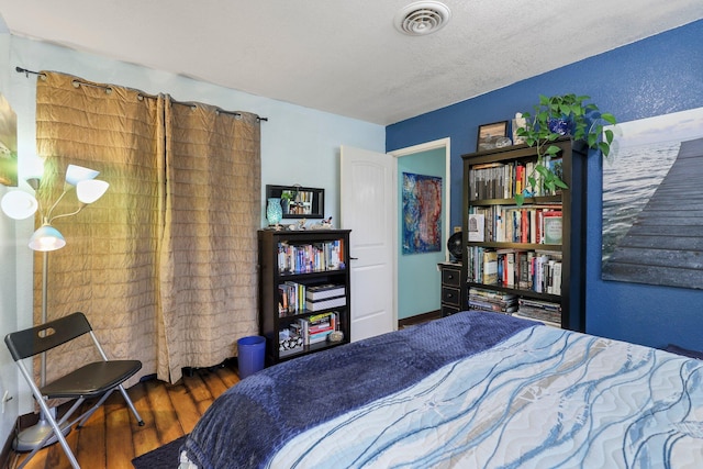 bedroom with visible vents and wood finished floors