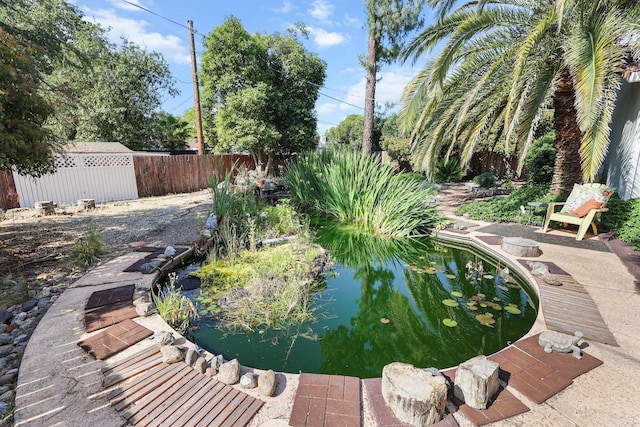 view of home's community featuring a fenced backyard and a garden pond