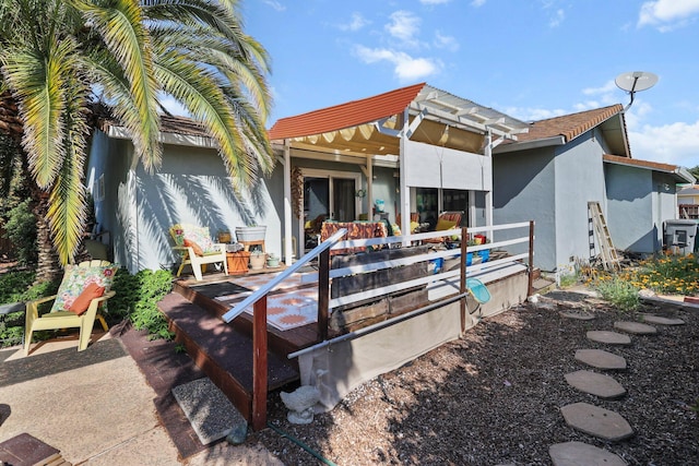 rear view of property with stucco siding and a deck