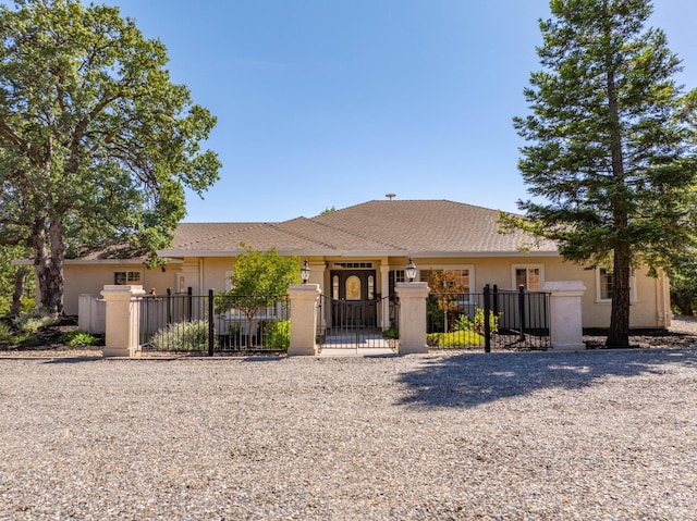 single story home featuring stucco siding, a fenced front yard, and a gate