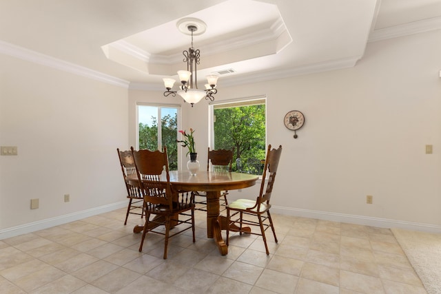 dining room with ornamental molding, a raised ceiling, a notable chandelier, and visible vents