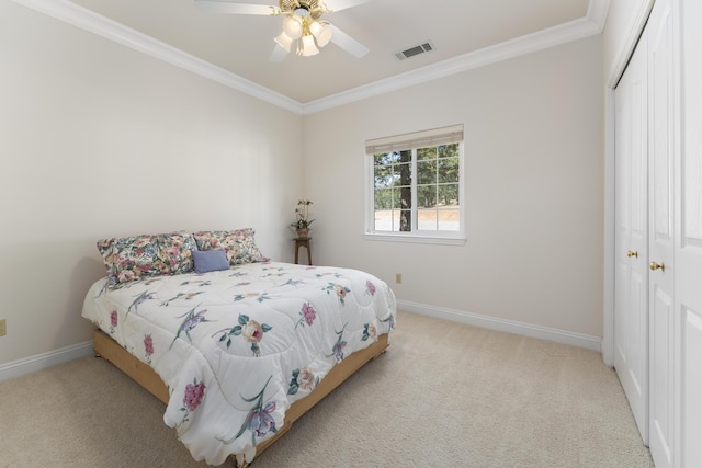 carpeted bedroom featuring a closet, visible vents, baseboards, and ornamental molding