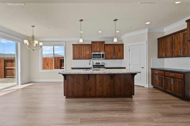 kitchen featuring a notable chandelier, light stone countertops, a sink, light wood-style floors, and stainless steel appliances