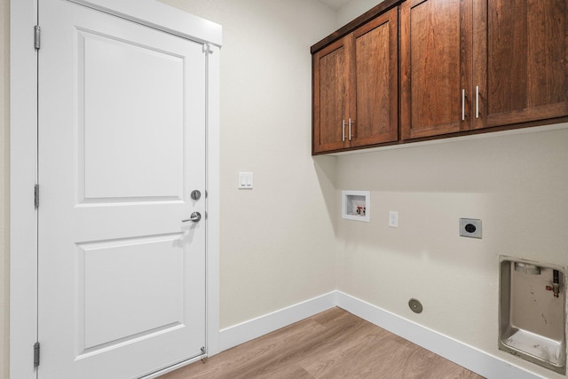 washroom featuring cabinet space, hookup for an electric dryer, light wood-type flooring, washer hookup, and baseboards