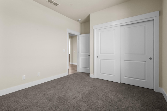 unfurnished bedroom with carpet floors, baseboards, visible vents, and a closet