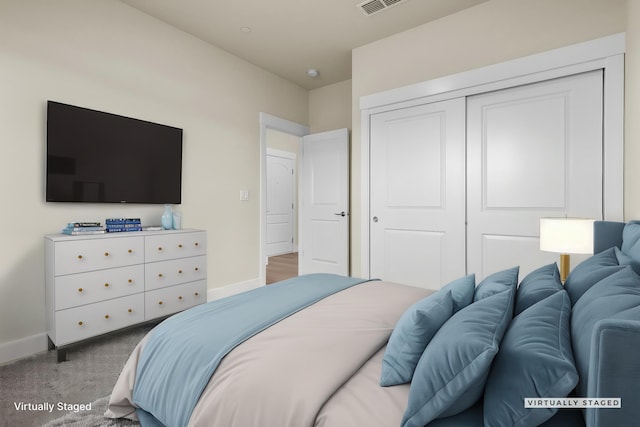 carpeted bedroom with baseboards and a closet