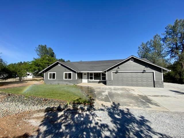 ranch-style home featuring driveway, a garage, and a front yard