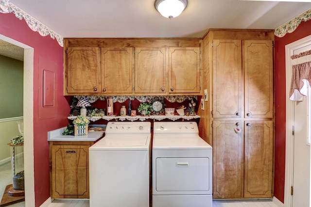 laundry area with cabinet space, washer and clothes dryer, and baseboards