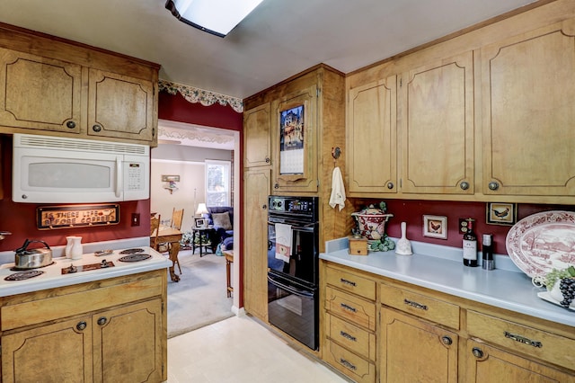kitchen featuring white microwave, light countertops, stovetop, and light flooring