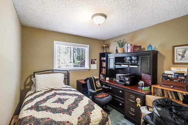bedroom featuring a textured ceiling, carpet flooring, and a desk