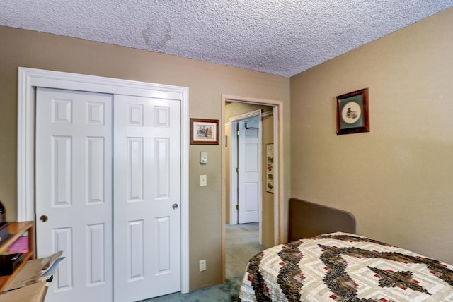 carpeted bedroom with a closet and a textured ceiling