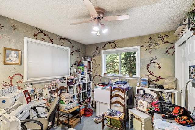 misc room featuring wallpapered walls, ceiling fan, and a textured ceiling