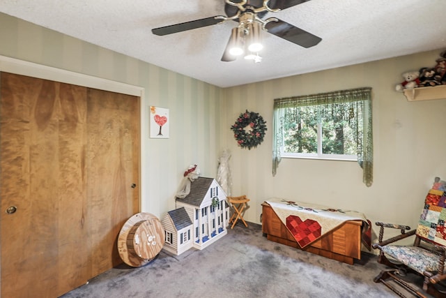 carpeted bedroom with a textured ceiling and a ceiling fan