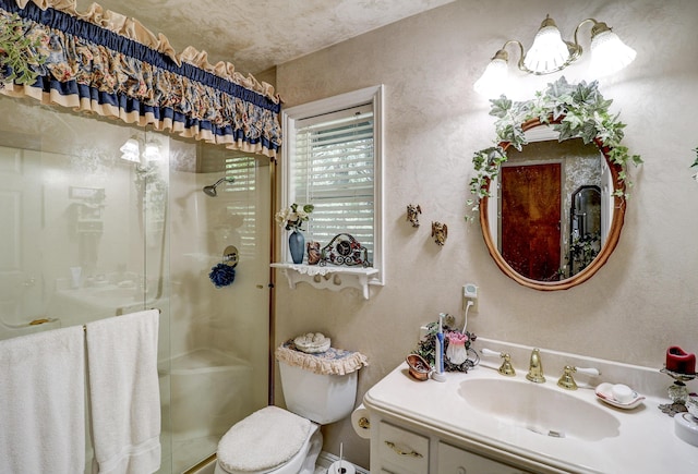 bathroom featuring a shower stall, toilet, and vanity