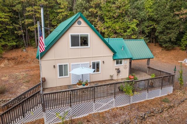 back of house with a wooden deck and metal roof