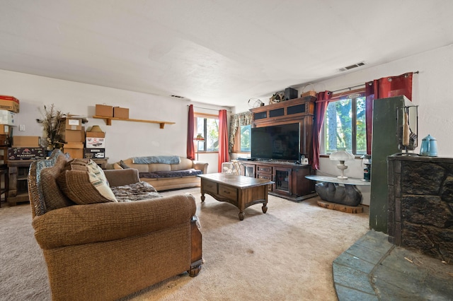 living room featuring light colored carpet, a wealth of natural light, and visible vents