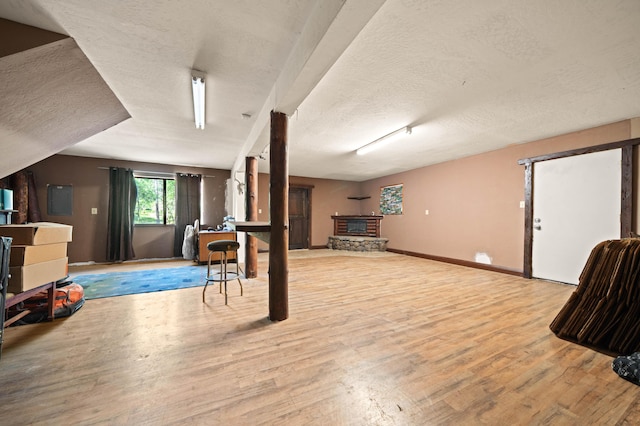 below grade area with a textured ceiling, wood finished floors, and baseboards