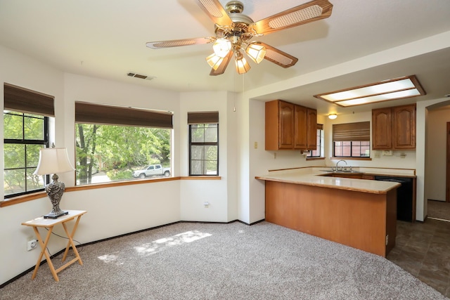 kitchen with brown cabinets, light countertops, and healthy amount of natural light