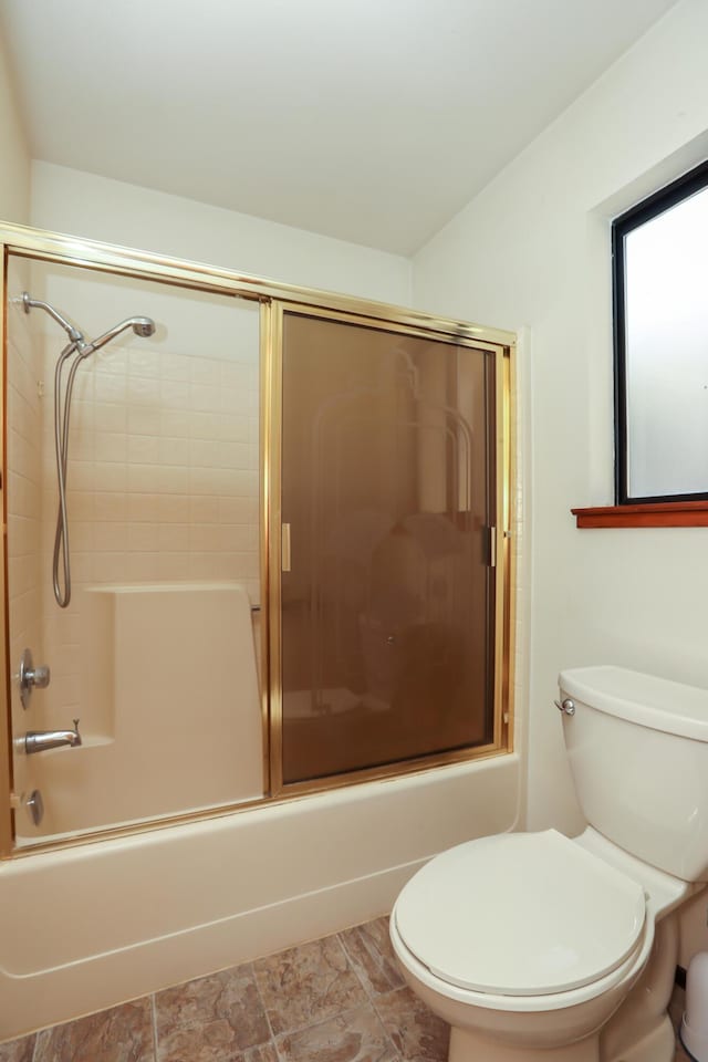 full bathroom with combined bath / shower with glass door and toilet