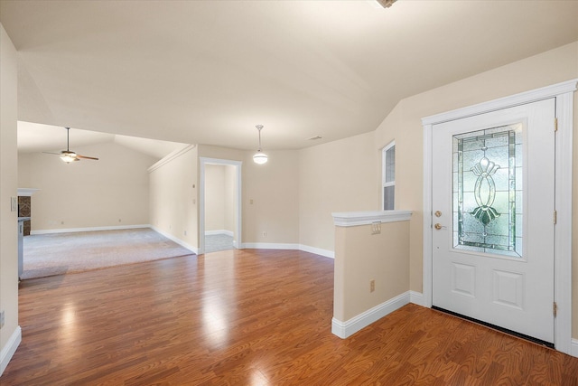 foyer entrance with vaulted ceiling, baseboards, and wood finished floors