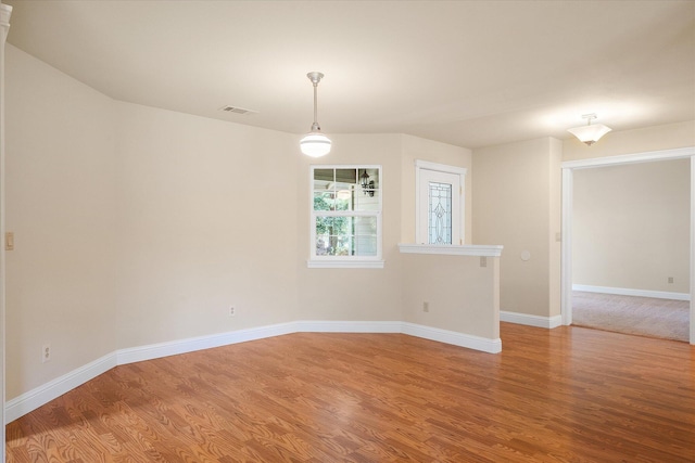 empty room featuring baseboards, light wood-type flooring, and visible vents