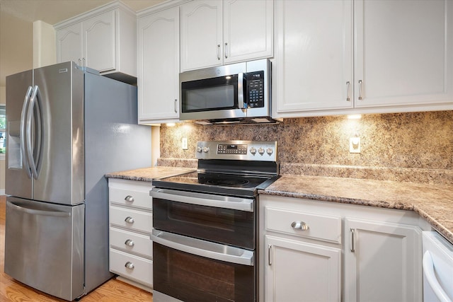 kitchen with light wood-style floors, stainless steel appliances, decorative backsplash, and white cabinets