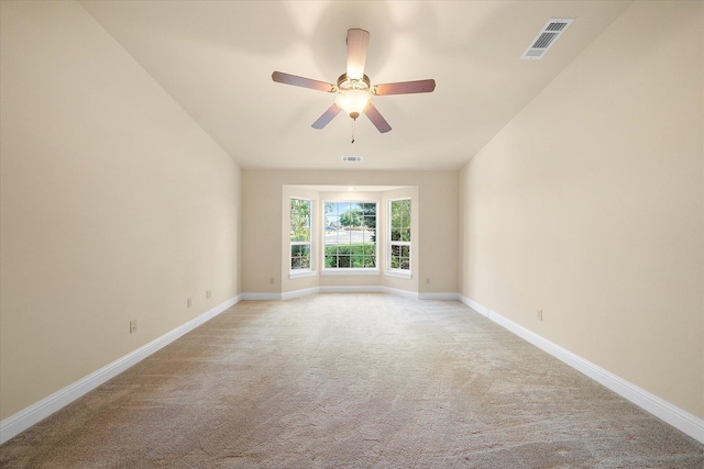 empty room featuring baseboards, ceiling fan, light carpet, and visible vents