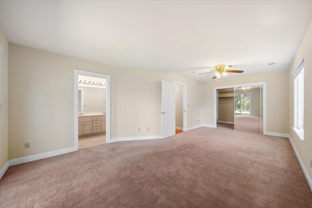 interior space featuring ceiling fan, light carpet, and baseboards