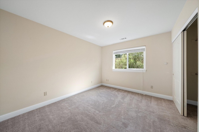 unfurnished bedroom with carpet, baseboards, a closet, and visible vents