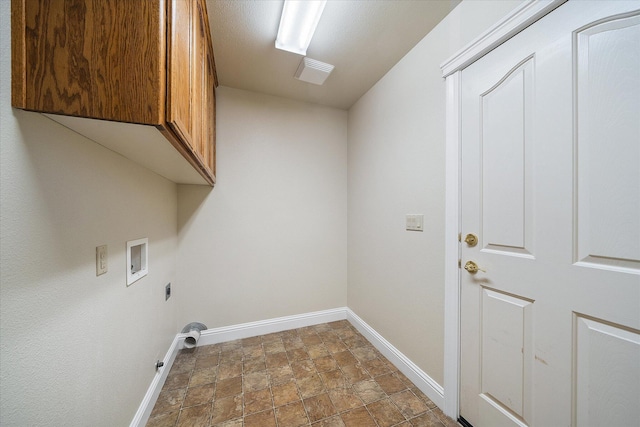 washroom featuring cabinet space, hookup for an electric dryer, stone finish flooring, washer hookup, and baseboards