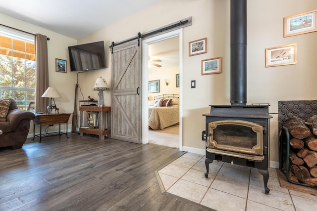 12637 Ivie Ln, Old Station, CA 96071 - living area featuring a barn door, a wood stove, wood finished floors, and baseboards