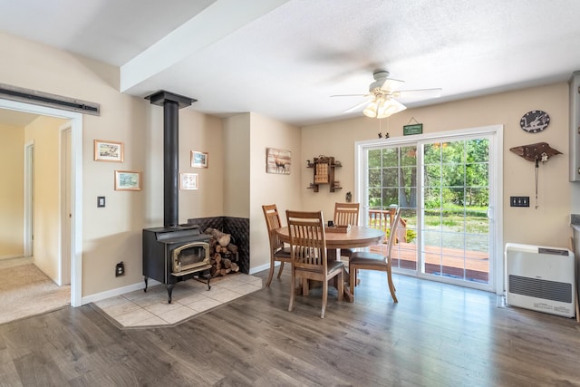 12637 Ivie Ln, Old Station, CA 96071 - dining area with heating unit, ceiling fan, a wood stove, wood finished floors, and baseboards