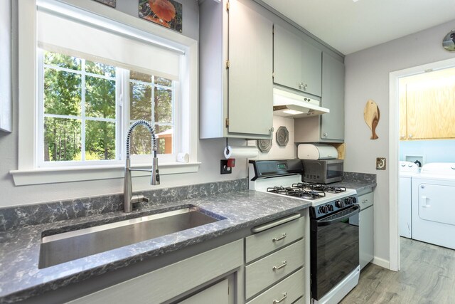 12637 Ivie Ln, Old Station, CA 96071 - kitchen with gas range, under cabinet range hood, a sink, washing machine and dryer, and healthy amount of natural light
