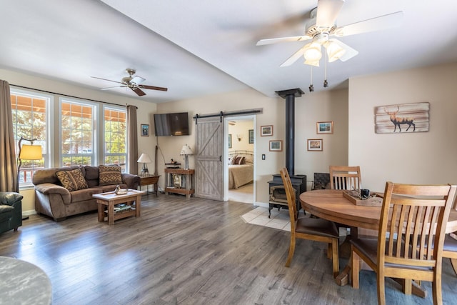 12637 Ivie Ln, Old Station, CA 96071 - dining area featuring ceiling fan, wood finished floors, a barn door, a wood stove, and baseboards