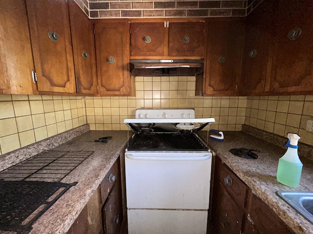 kitchen featuring white electric range oven, brown cabinets, decorative backsplash, and under cabinet range hood