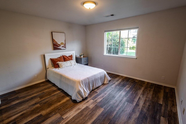 bedroom with dark wood finished floors and baseboards