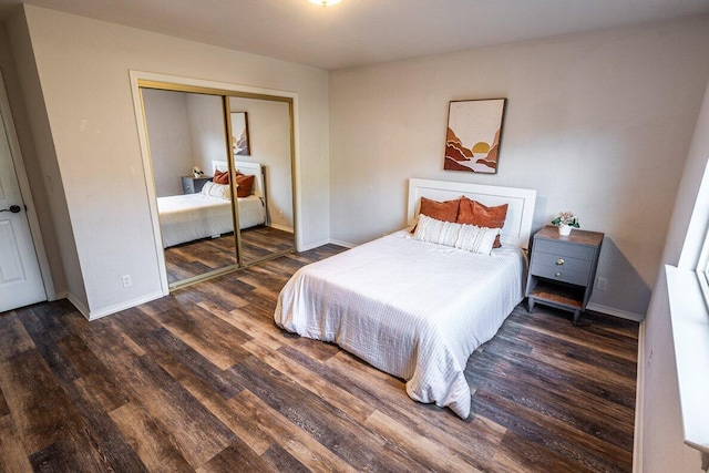 bedroom with wood finished floors, a closet, and baseboards