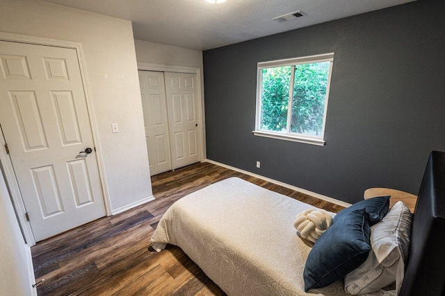 bedroom featuring wood finished floors, baseboards, and a closet