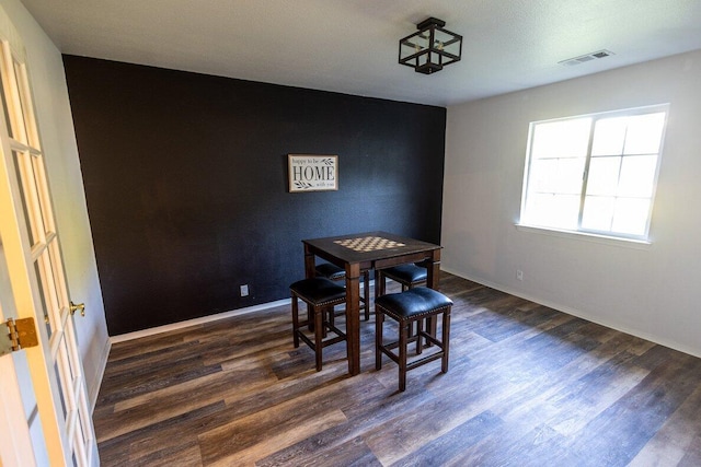 dining space with dark wood-type flooring and baseboards