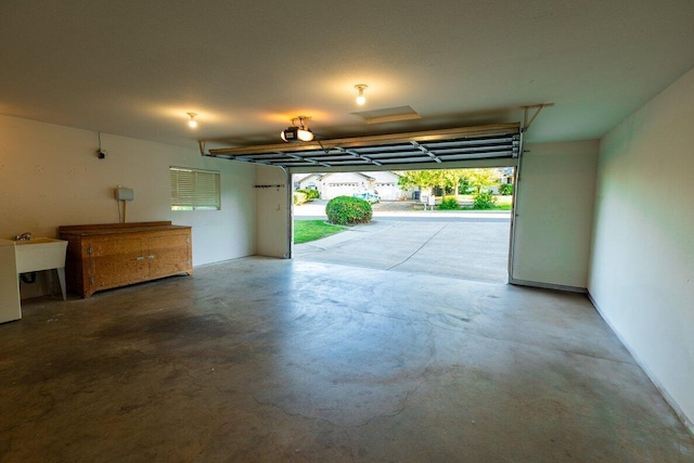 garage with a garage door opener and a sink